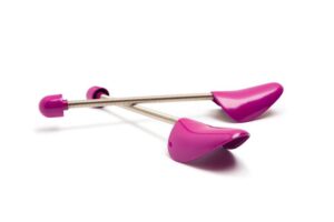 A pair of pink plastic spiral shoe trees with adjustable metal springs is displayed against a white background, providing an effective alternative for maintaining shoe shape.